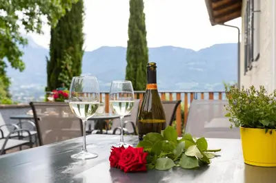 a bottle of wine and two glasses on a table at MeranoView Apartments in Marlengo