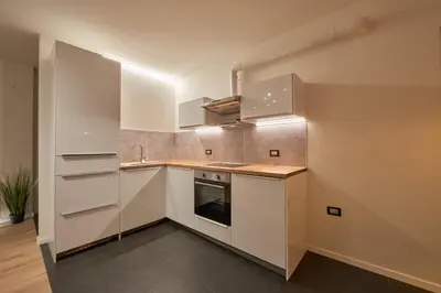 a kitchen with white cabinets and a sink at Villa Romana Meran in Merano