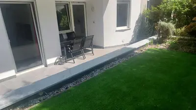 a patio with a green lawn in front of a house at Villa Romana Meran in Merano
