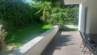 a porch of a house with a green lawn at Villa Romana Meran in Merano