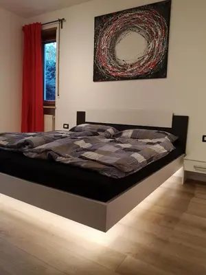 a bedroom with a bed with a comforter on it at Villa Romana Meran in Merano