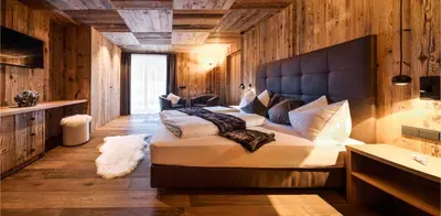 a bedroom with a large bed with a large headboard at Mi Coa in Santa Cristina in Val Gardena