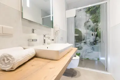 a bathroom with a large white sink and a shower at Residence Bergblick in Bressanone