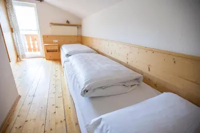 two beds in a room with a wooden floor at Residence Bergblick in Bressanone