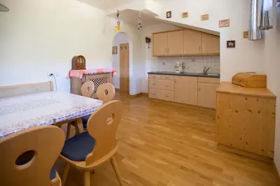 a kitchen with a table and chairs in a room at Residence Bergblick in Bressanone