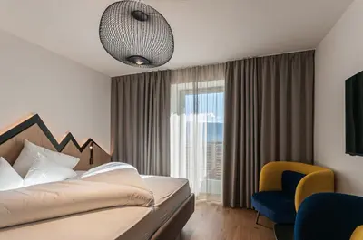 a hotel room with a bed and a window at Alpin & Stylehotel Die Sonne in Parcines