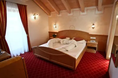 a bedroom with a large bed in a room at Alpin & Stylehotel Die Sonne in Parcines