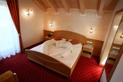 a bedroom with a large bed in a room at Alpin & Stylehotel Die Sonne in Parcines