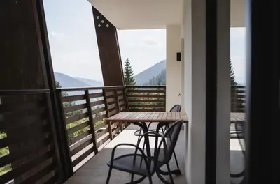 a table and chairs on a balcony with a view at Hotel Rosengarten in Nova Levante
