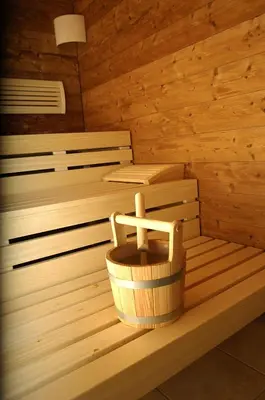 a wooden sauna with a wooden basket in it at Hotel Rosengarten in Nova Levante