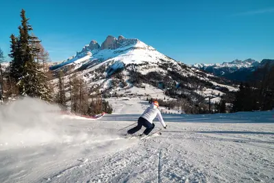 a man is skiing down a snow covered mountain at Hotel Rosengarten in Nova Levante