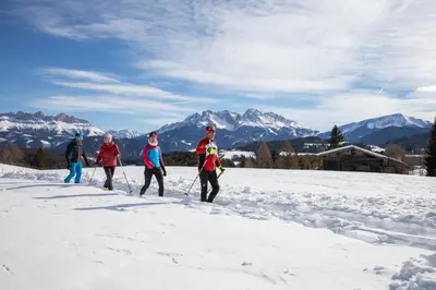 a group of people cross country skiing in the snow at Hotel Rosengarten in Nova Levante