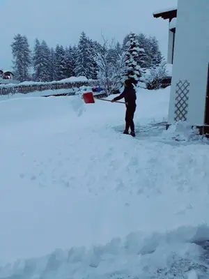 a person is shoveling snow off of a house at Haus Elisabeth in Nova Ponente