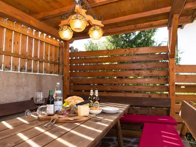 a wooden table with wine glasses on a patio at Haus Elisabeth in Nova Ponente