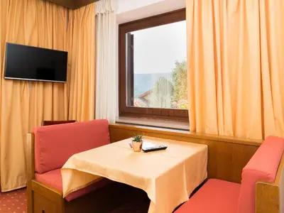 a room with a table and two chairs and a window at Haus Elisabeth in Nova Ponente