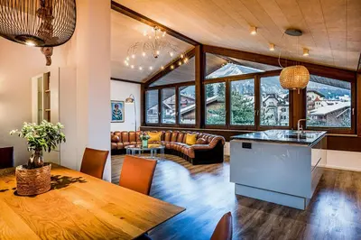 a kitchen and living room with a table and chairs at Apartments Rumanon in Ortisei