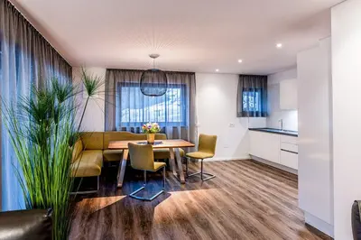 a kitchen and dining room with a table and chairs at Apartments Rumanon in Ortisei