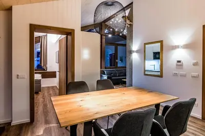 a dining room with a wooden table and chairs at Apartments Rumanon in Ortisei