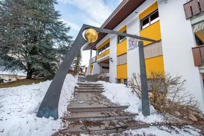 a building with stairs in the snow in front of it at Apartments Rumanon in Ortisei