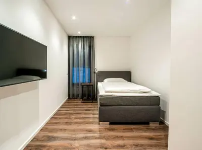 a bedroom with a bed and a flat screen tv at Apartments Rumanon in Ortisei