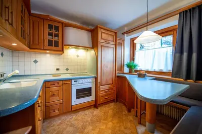 a kitchen with wooden cabinets and a blue counter top at Apartment Sellablick in Ortisei