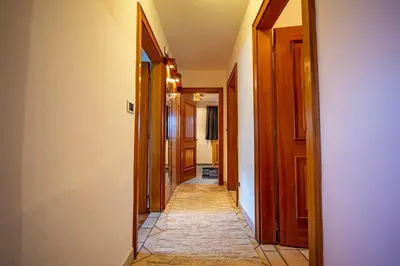 a hallway with wooden doors and a tile floor at Apartment Sellablick in Ortisei