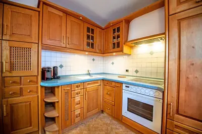 a kitchen with wooden cabinets and a sink and a stove at Apartment Sellablick in Ortisei