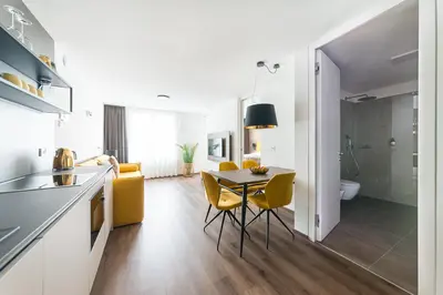 a kitchen and dining room with a table and yellow chairs at Gerharts Premium City Living - center of Brixen with free parking and Brixencard in Bressanone