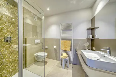 a bathroom with a sink and a toilet and a shower at Ferienhaus Törggelehof in Cermes