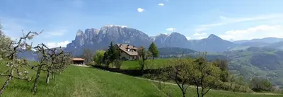 a house on a hill with mountains in the background at Birbamergut in Longomoso