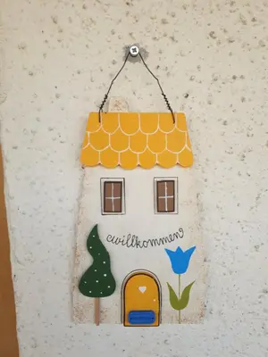 a house shaped house ornament hanging on a wall at Birbamergut in Longomoso