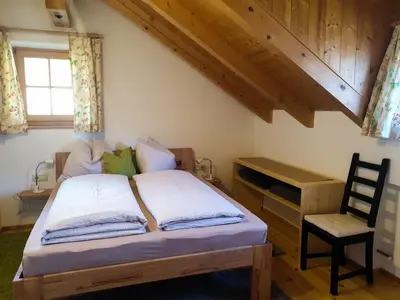 a bedroom with a bed with a chair and a desk at Birbamergut in Longomoso