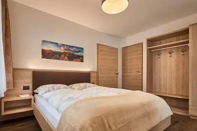 a bedroom with a large bed and wooden cabinets at Saina in Colfosco
