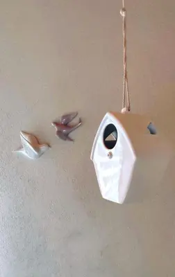 a bird feeder hanging from the ceiling with two birds at Regina del Bosco della vicina Cavalese in Daiano