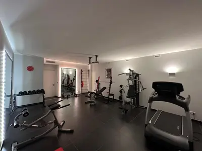 a gym with several treadmills and machines in a room at VILLA COLLINA VERDE in Bolzano