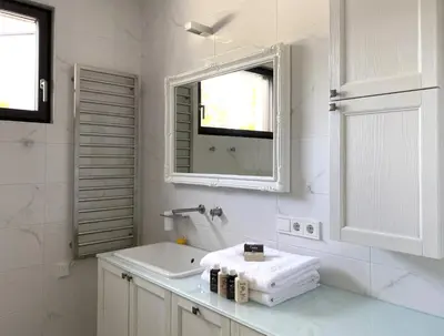 a white bathroom with a sink and a mirror at VILLA COLLINA VERDE in Bolzano