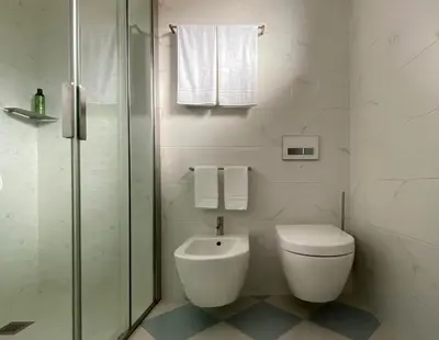 a white bathroom with a toilet and a shower at VILLA COLLINA VERDE in Bolzano