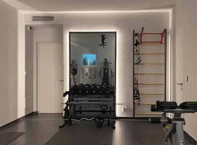 a gym with a mirror and some exercise equipment at VILLA COLLINA VERDE in Bolzano