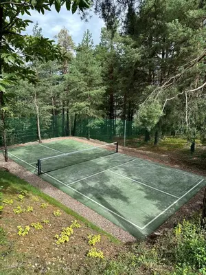 a tennis court in a park with trees at VILLA COLLINA VERDE in Bolzano