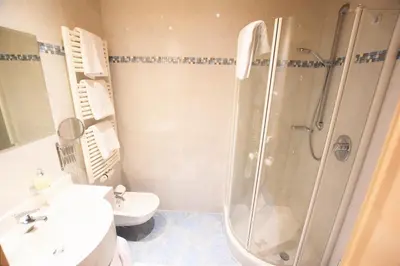 a bathroom with a shower and a sink and a toilet at Residence Palmai in Ortisei