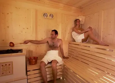 a man and woman sitting in a sauna at Residence Palmai in Ortisei