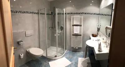 a bathroom with a shower and a toilet and a sink at Residence Palmai in Ortisei