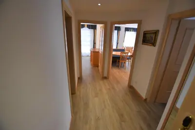 a hallway with a dining room and a dining table at Residence Palmai in Ortisei