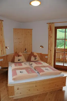 a bedroom with a large wooden bed in a room at Zangerlechnhof in Brunico