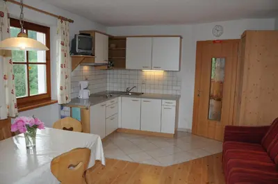 a kitchen and living room with a table and a couch at Zangerlechnhof in Brunico