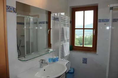 a bathroom with a sink and a mirror and a window at Zangerlechnhof in Brunico