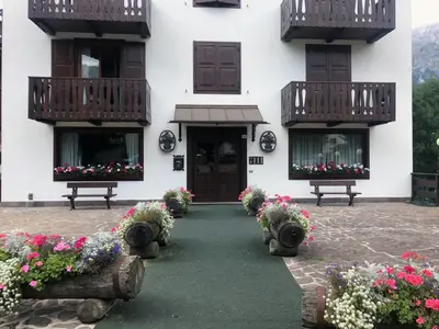 a living room with green couches and a table at Cortina Olympic Suite in Cortina dʼAmpezzo