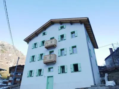 a white building with balconies on the side of it at La Rocia 2 in Rocca Pietore