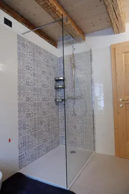 a bathroom with a shower with a glass door at La Rocia 2 in Rocca Pietore