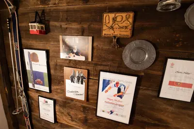 a wall with posters and pictures on it at Kronplatz Ski Lodge in Valdaora